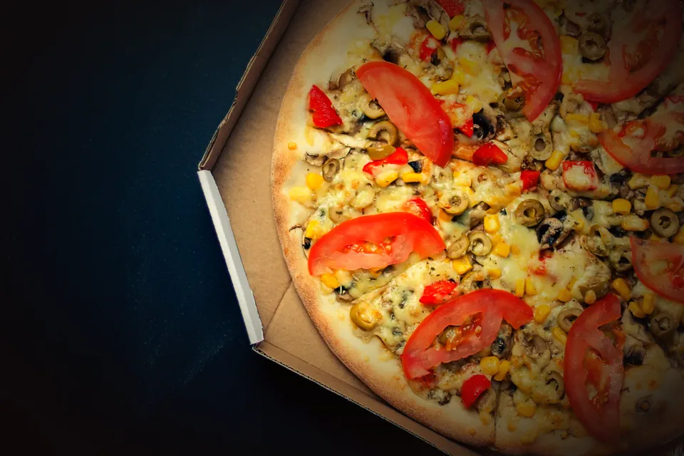 Pizza de tomate, milho e azeitona inteira, na caixa
